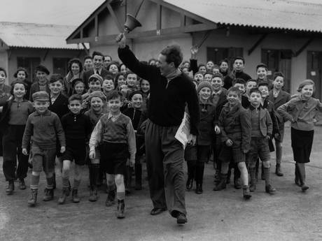 11th January 1939: A camp leader ringing the dinner bell at a camp for young Jewish refugees from Germany and Austria, at Dovercourt Bay near Harwich (Fox Photos/Getty Images)